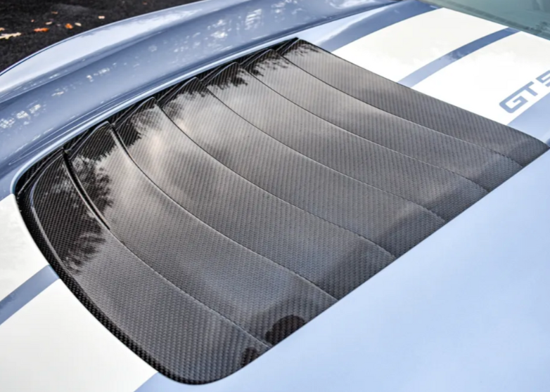 a carbon fiber hood vent installed on a blue and white striped GT500