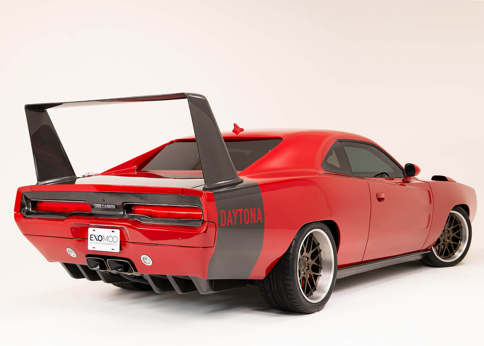 A red '69 Dodge Charger showing an installed carbon fiber rear wing