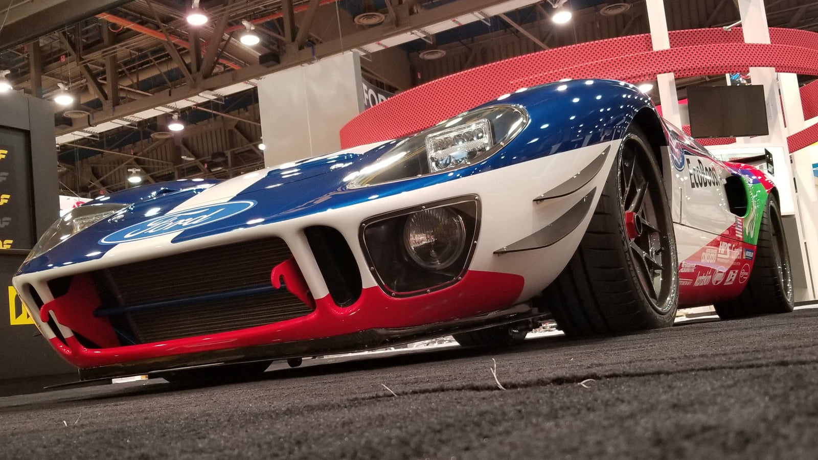 A GT40 at an expo with installed carbon fiber front lip and canards