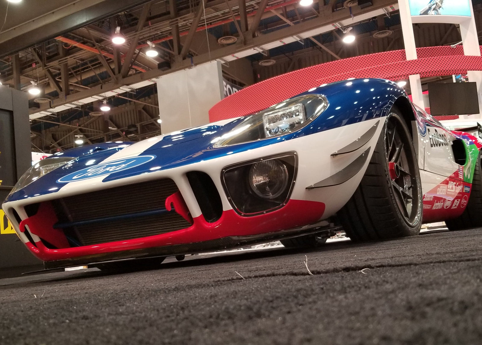 A GT40 at an expo with installed carbon fiber front lip and canards