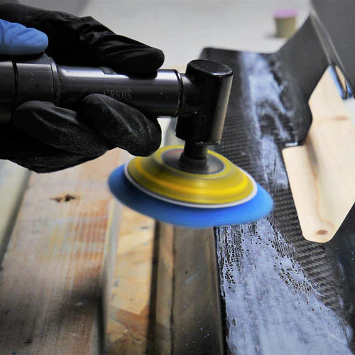 A person polishes a carbon fiber part