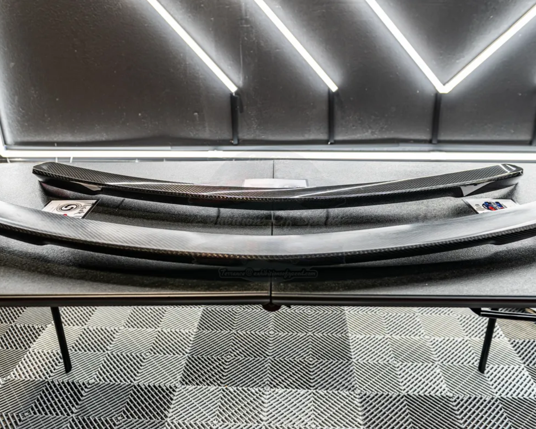 a carbon fiber finished rear spoiler sitting on a table