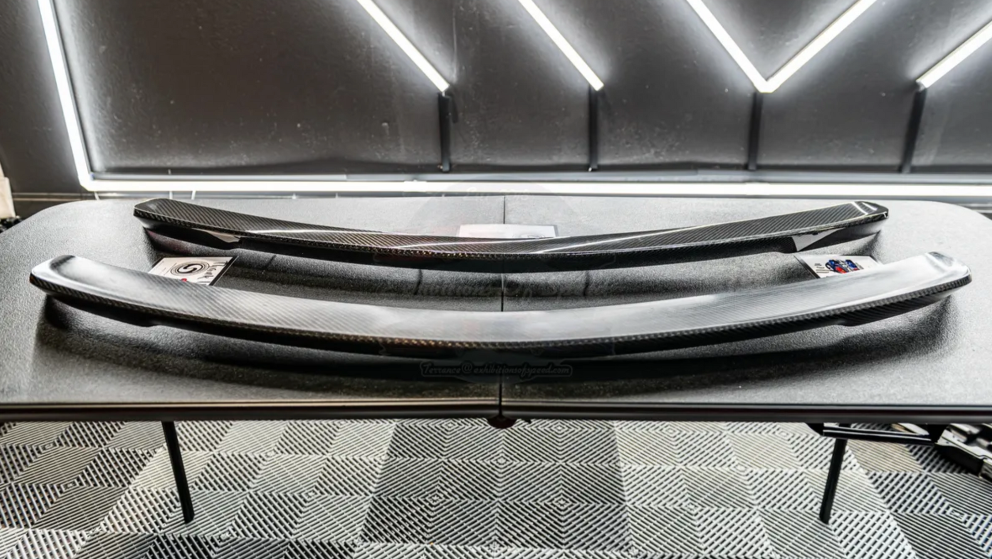 a carbon fiber finished rear spoiler sitting on a table