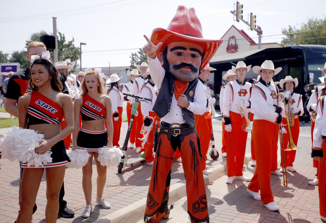 Pistol Pete cheering in a crowd of cheerleaders and band members